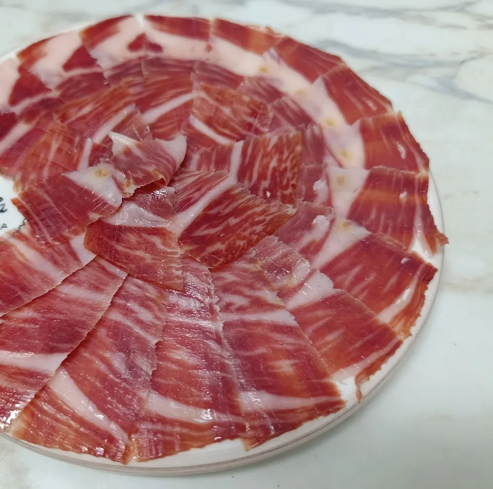 Assiette de jambon ibérique tranché au couteau, disposé en rosace