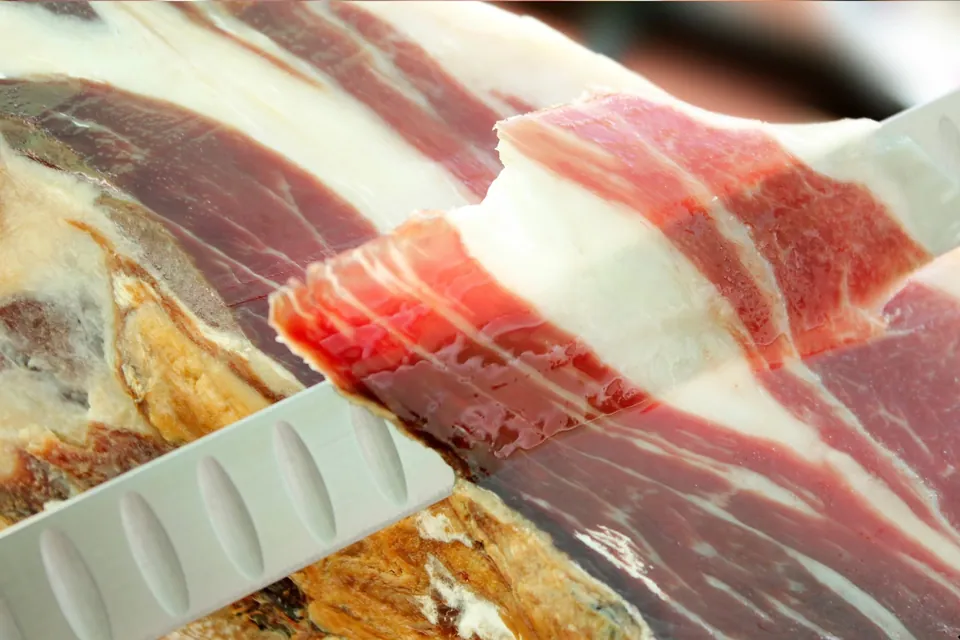 Découpe au couteau d’une tranche de jambon ibérique